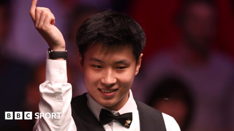 Zhao Xintong smiles while raising his arm